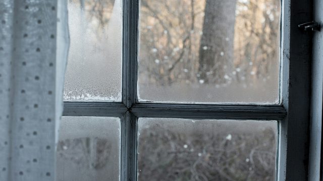 冬の朝、結露で水滴がびっしり付いた窓ガラス